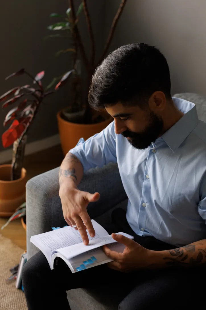 Júlio lendo um livro de psicologia no sofá do consultório